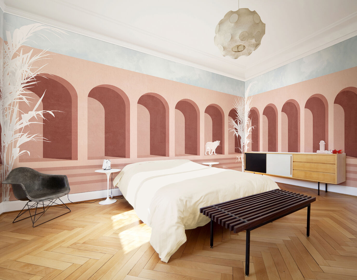 Bett in einem Raum mit zartrosa Tapete