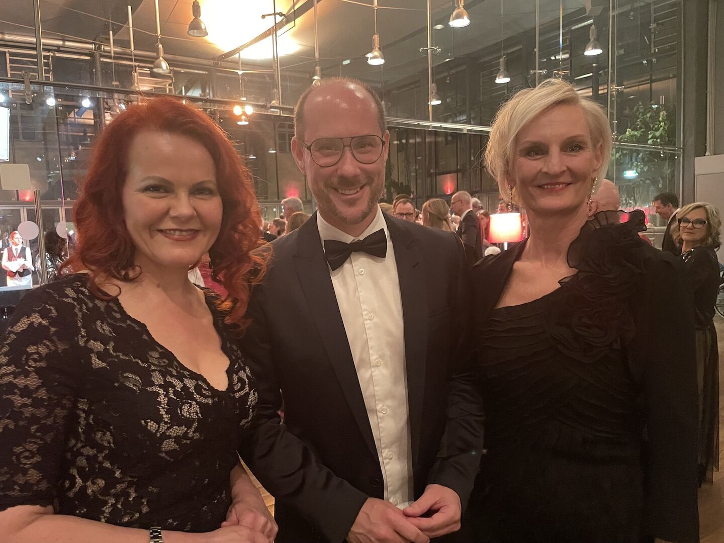 ein Mann mit zwei Damen in Ballrobe