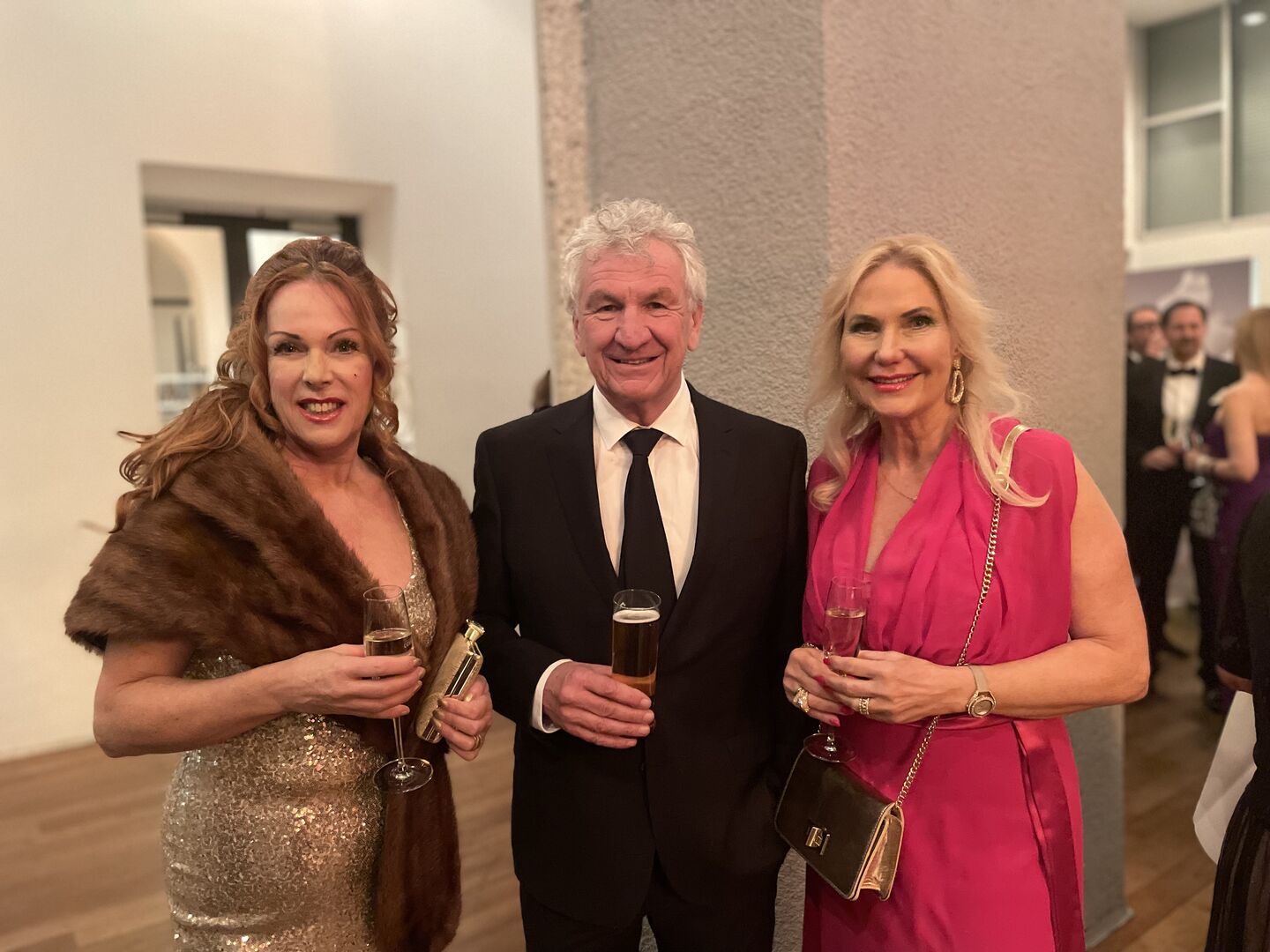 zwei Frauen und Mann am Ball