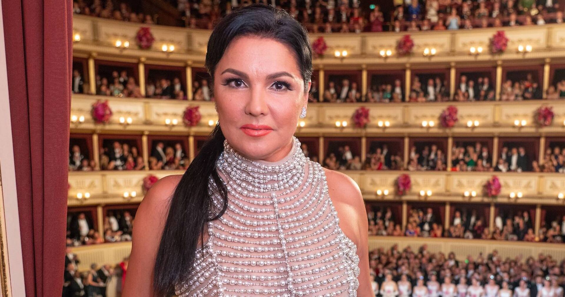 Anna Netrebko mit perlenbesetztem Oberteil und schwarzem, langem, hochgestecktem Haar.