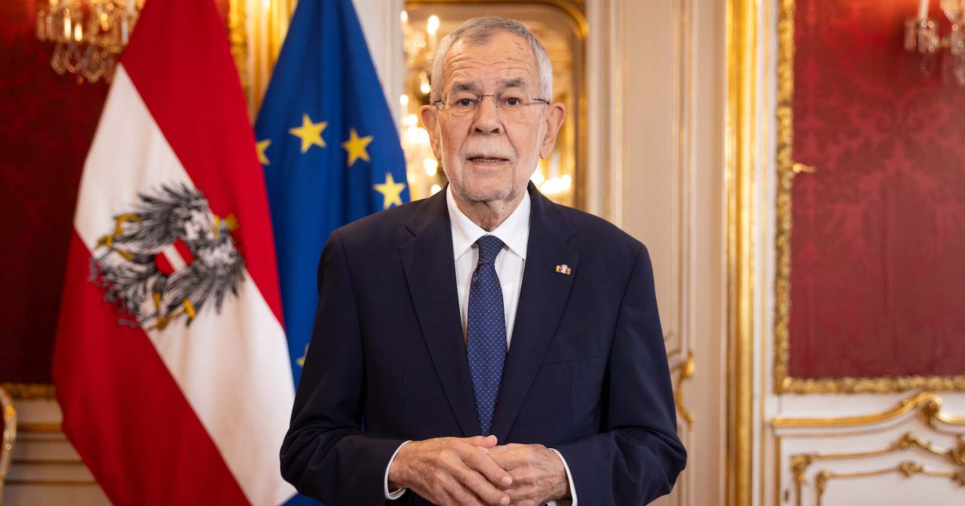 Alexander Van der Bellen hält eine Ansprache in der Präsidentschaftskanzlei der Hofburg, hinter ihm die österreichische und europäische Flagge.