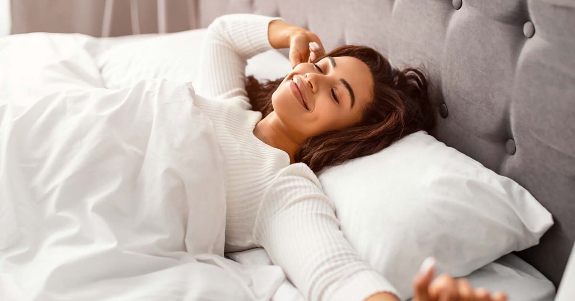 Frau erwacht glücklich aus dem Schlaf | Credit: iStock.com/Prostock-Studio