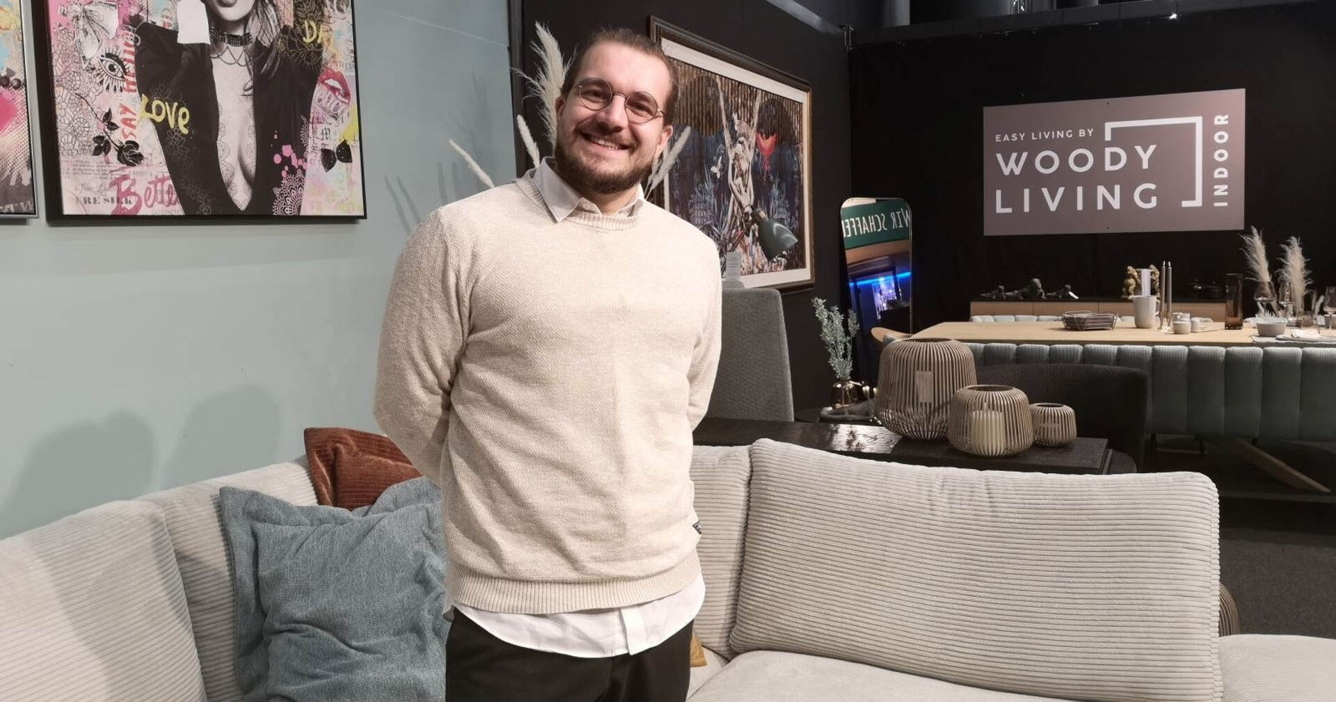 Daniel Feilmayr von WoodyLiving vor einer Couch und Essgruppe.