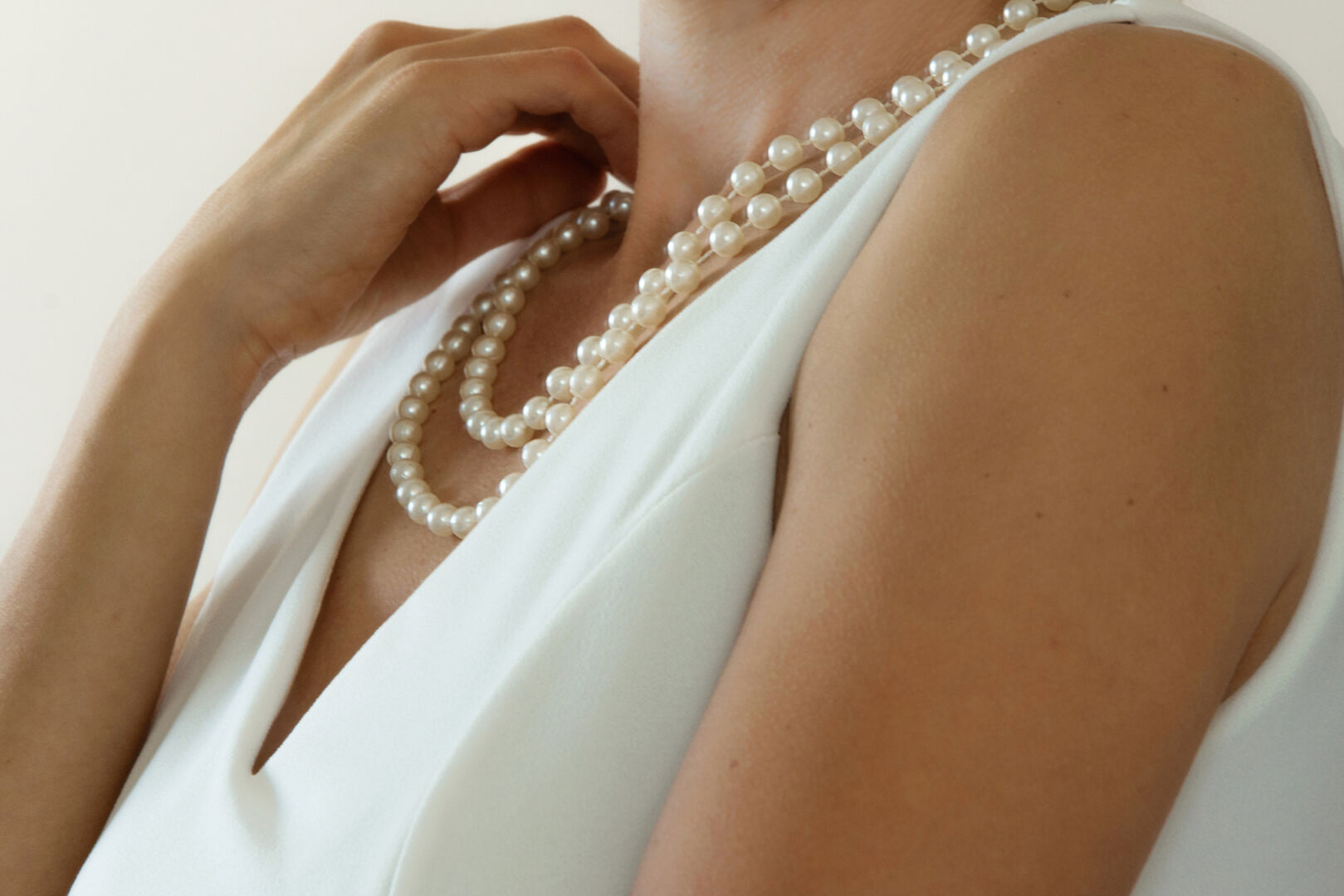 Frau trägt Perlenkette | Credit: iStock.com/Alikaj2582