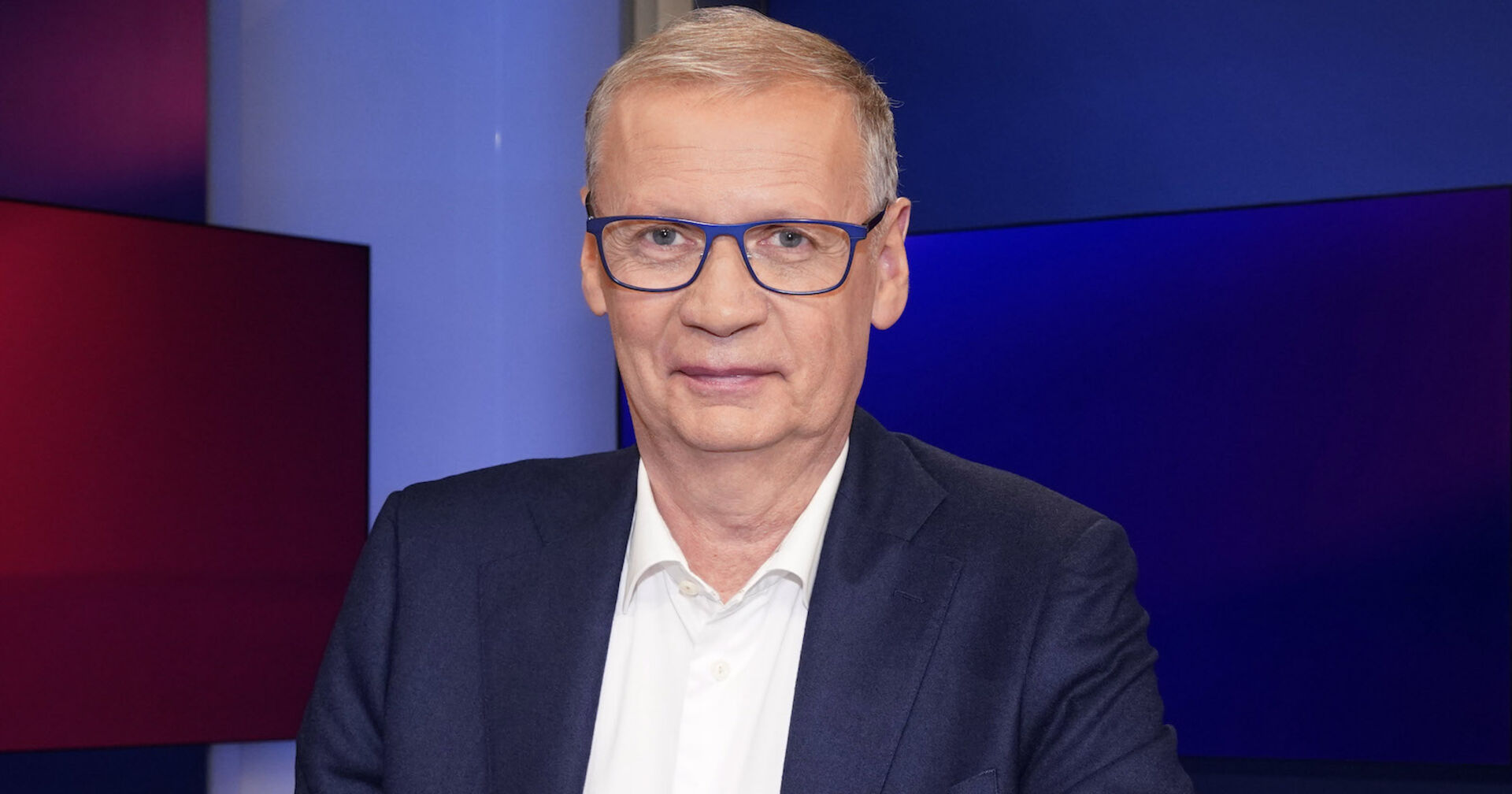 Günther Jauch trägt einen Anzug und ein weißes Hemd.