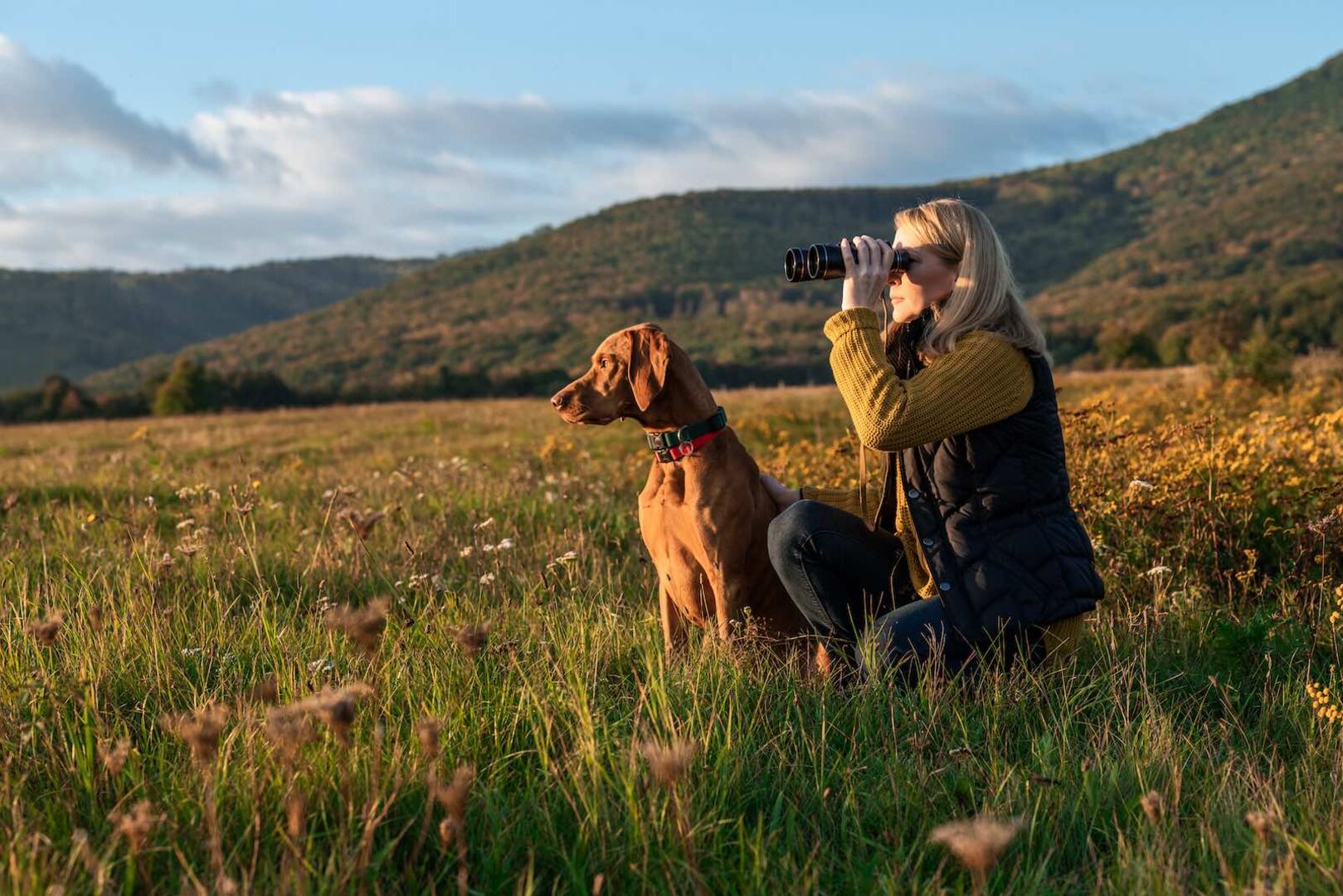 Eine Frau mit ihrem Hund bei der Jagd.