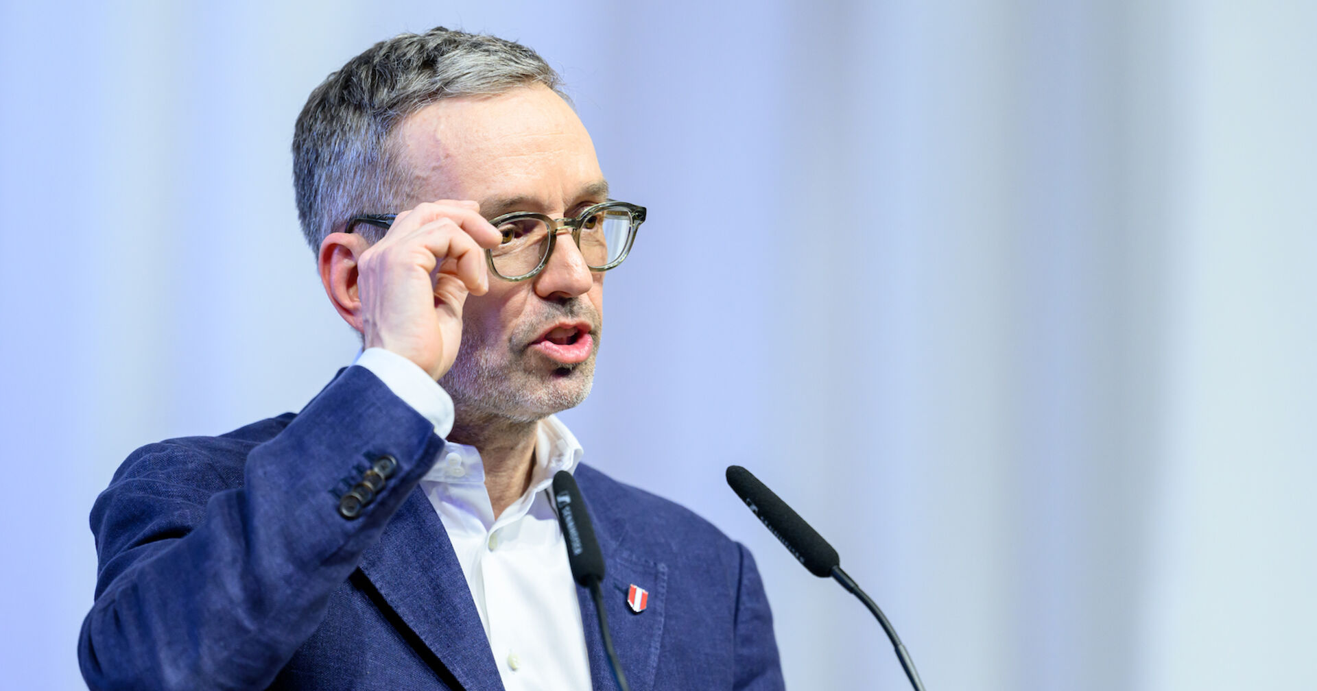 Herbert Kickl mit Brille im Porträt am Rednerpult