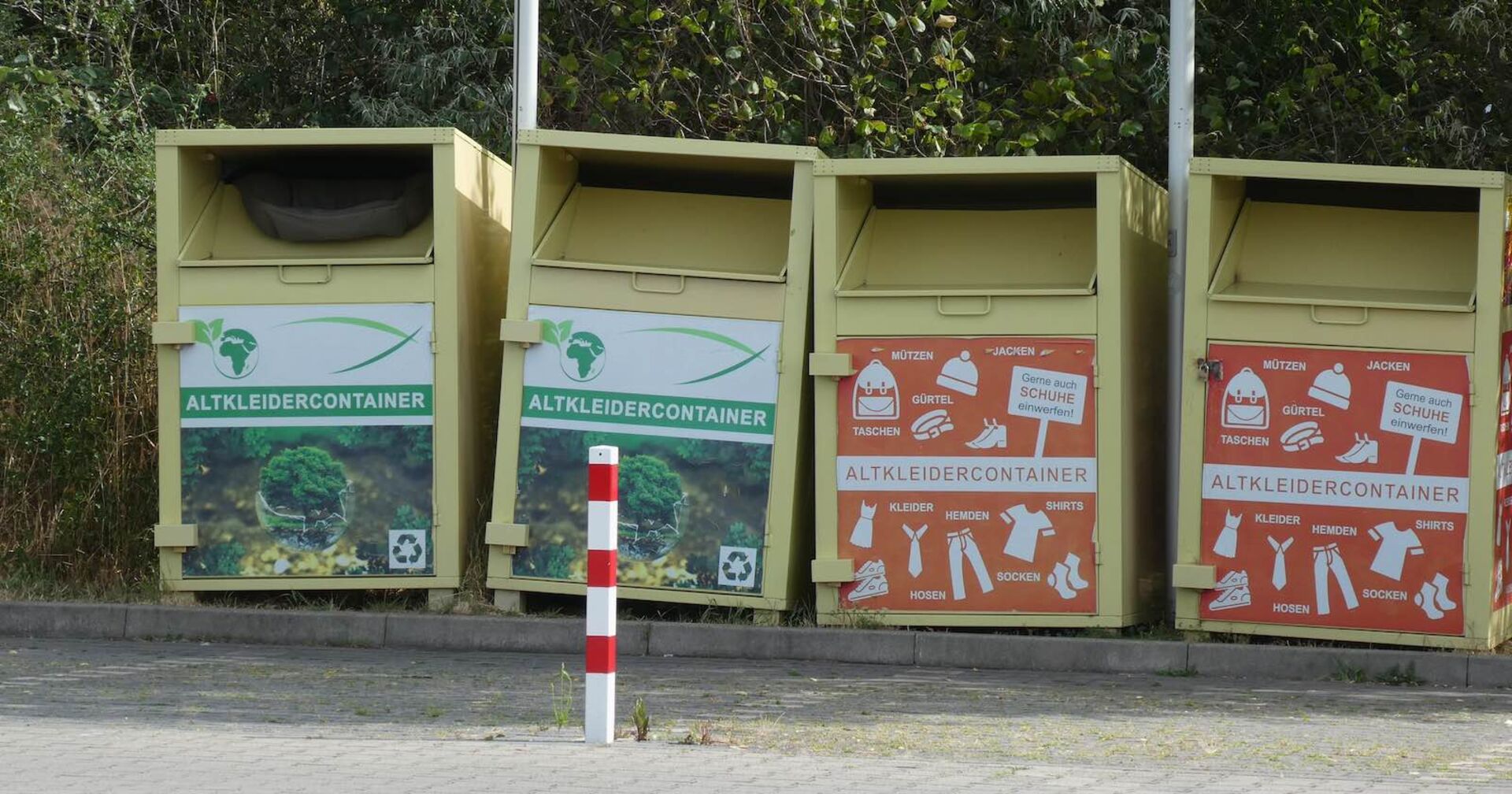 Vier Altkleidercontainer nebeneinander.