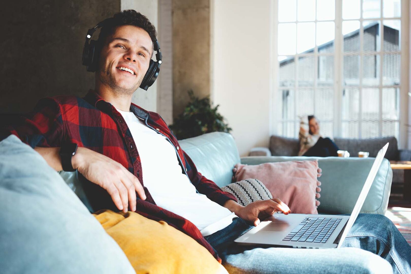 Mann sitzt mit Laptop auf der Couch | Credit: iStock.com/littlehenrabi