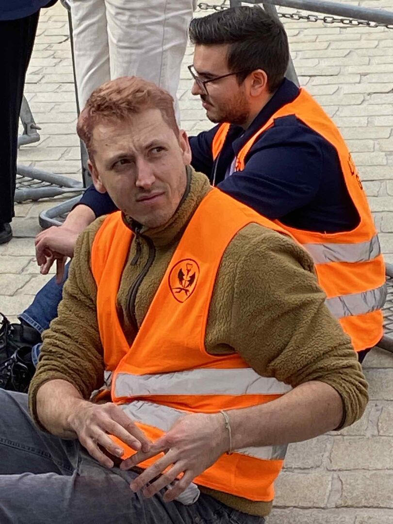 Martin Schütter sitzt mit anderen Demonstranten vor dem Parlament.