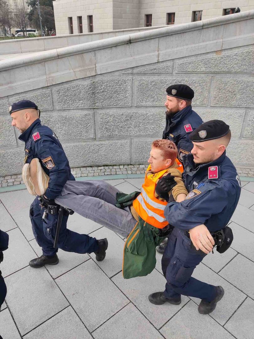 Drei Polizisten tragen Martin Schütter vom Parlament weg.