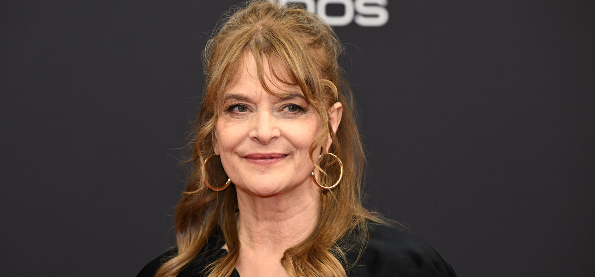 Nastassja Kinski auf einem Event vor einer schwarzen Fotoleinwand.