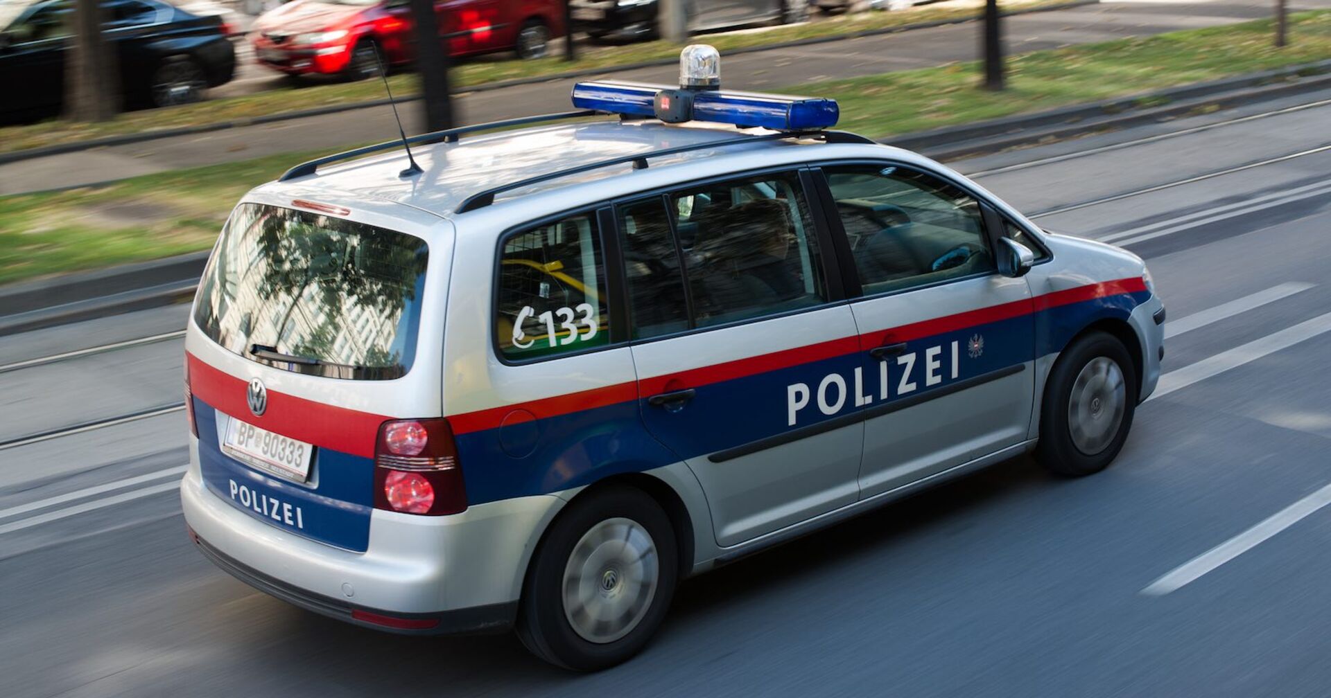 Ein Polizeiauto fährt auf einer Straße.