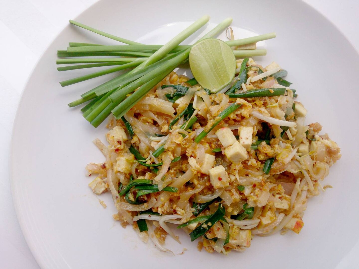 Teller mit gebratenen Reisnudeln, Frühlingszwiebeln und Tofu, auch bekannt als &quot;Pad Thai&quot;.