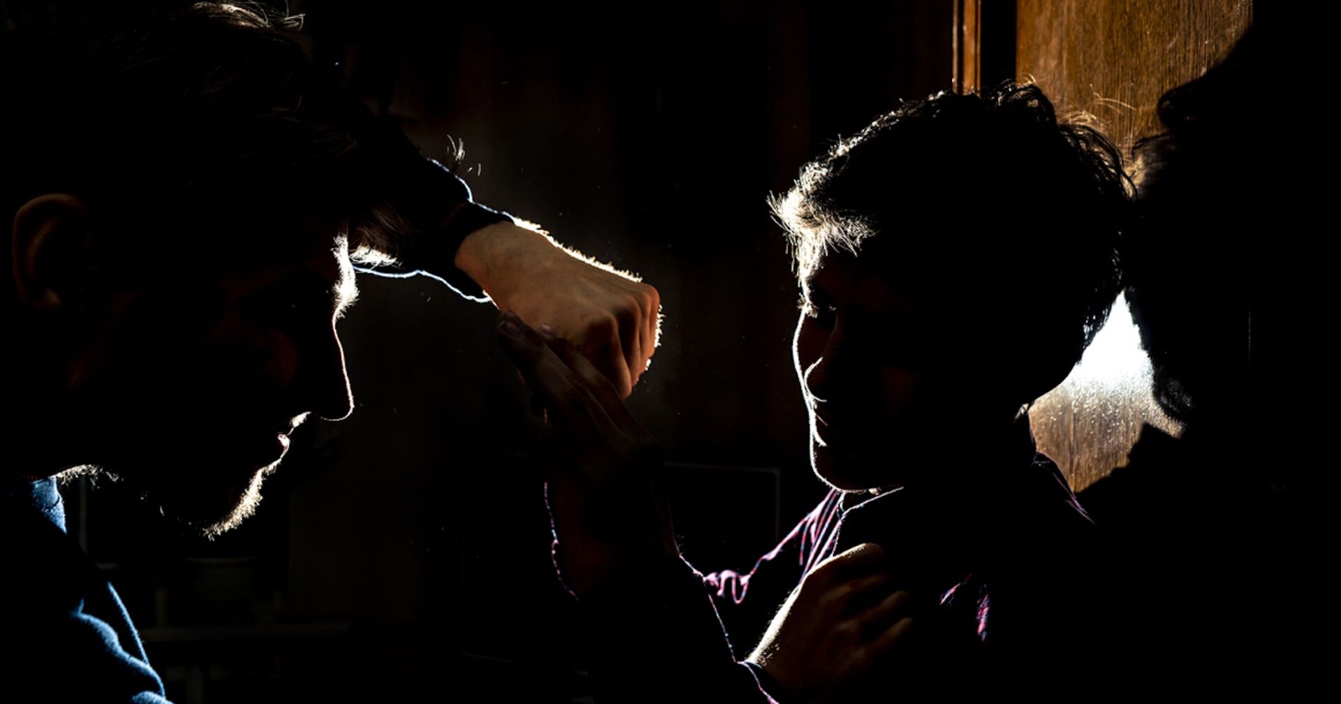 Ein Mann verprügelt im Dunkeln einen anderen Mann.