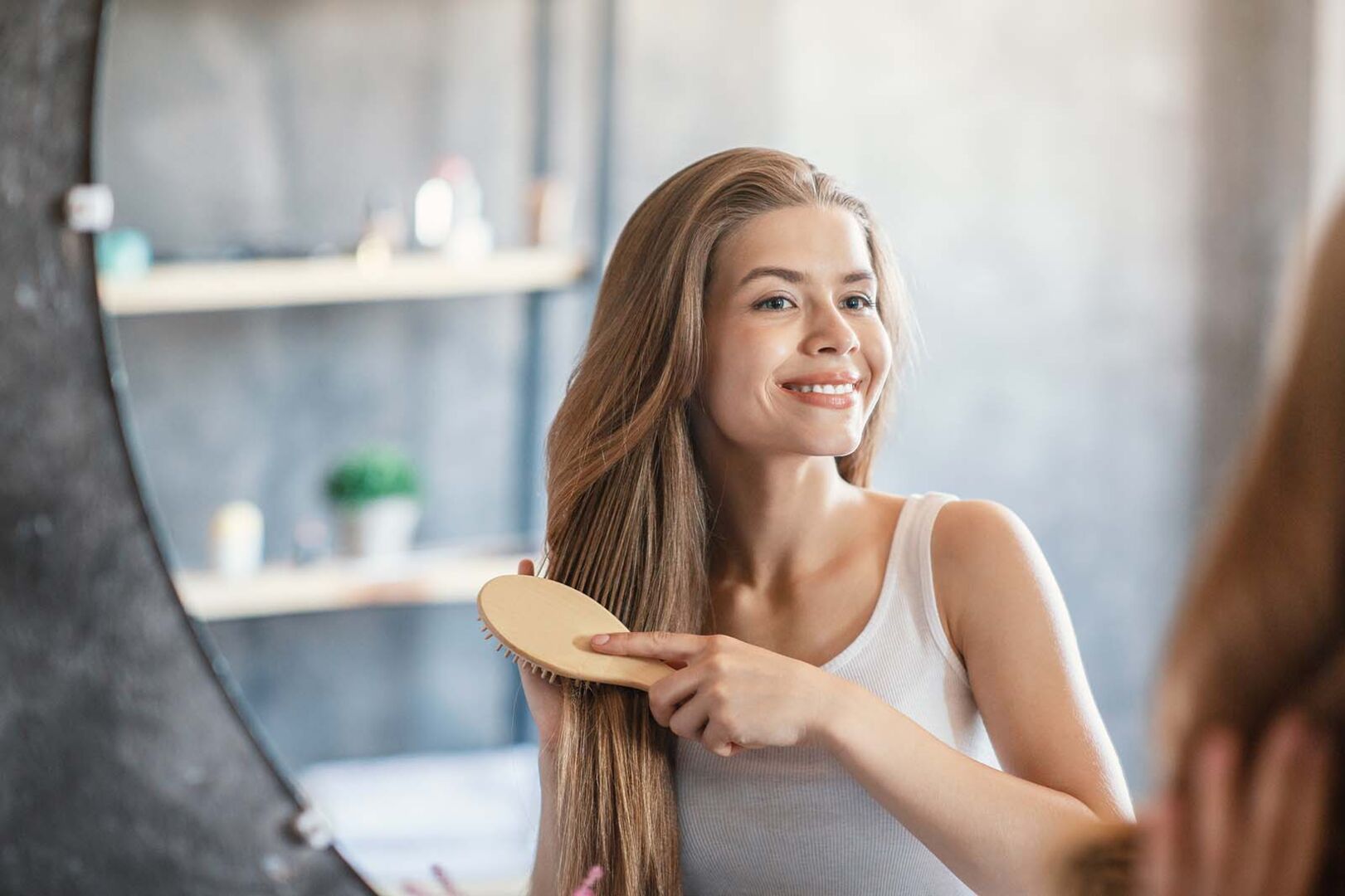 Frau bürstet sich die Haare | Credit: iStock.com/Prostock-Studio