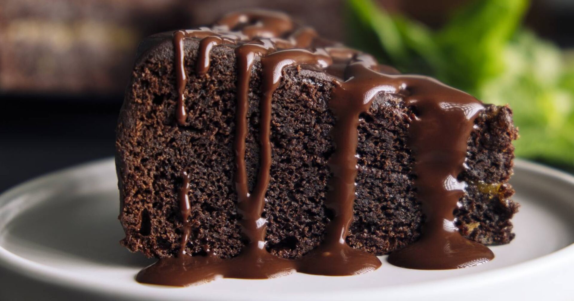 Teller mit einem Stück Schokoladenkuchen, garniert mit flüssiger Schokosauce