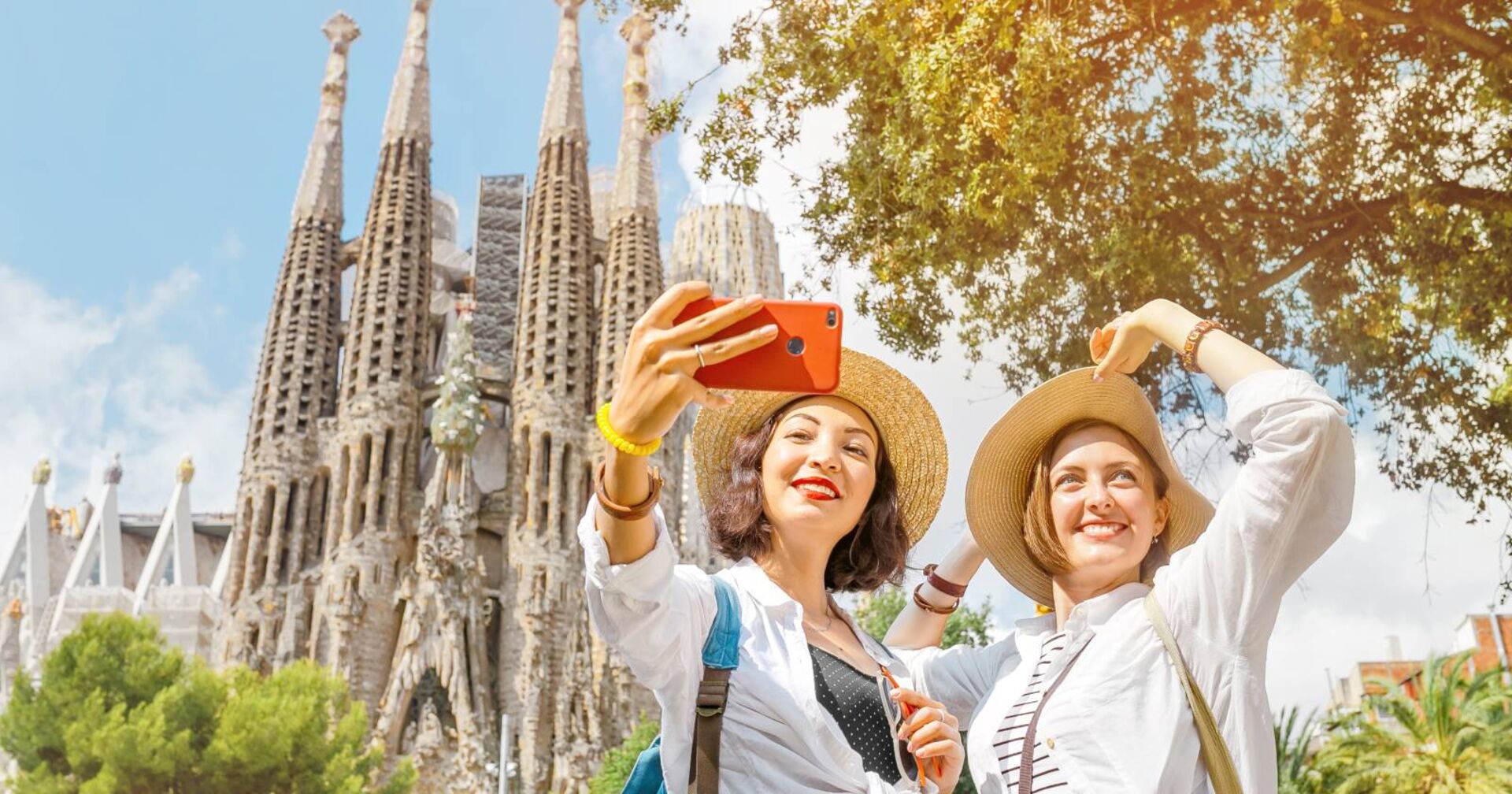 Zwei Frauen machen ein Selfie vor der Kathedrale Sagrada Familia in Barcelona