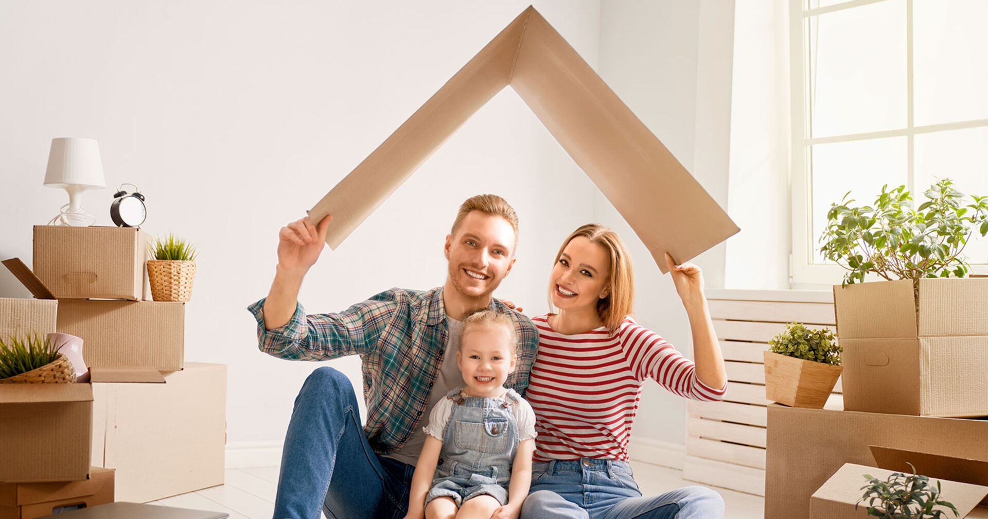 Junges Elternpaar mit Tochter unter einem Kartondach | Credit: Colourbox.de/Konstantin Yuganov