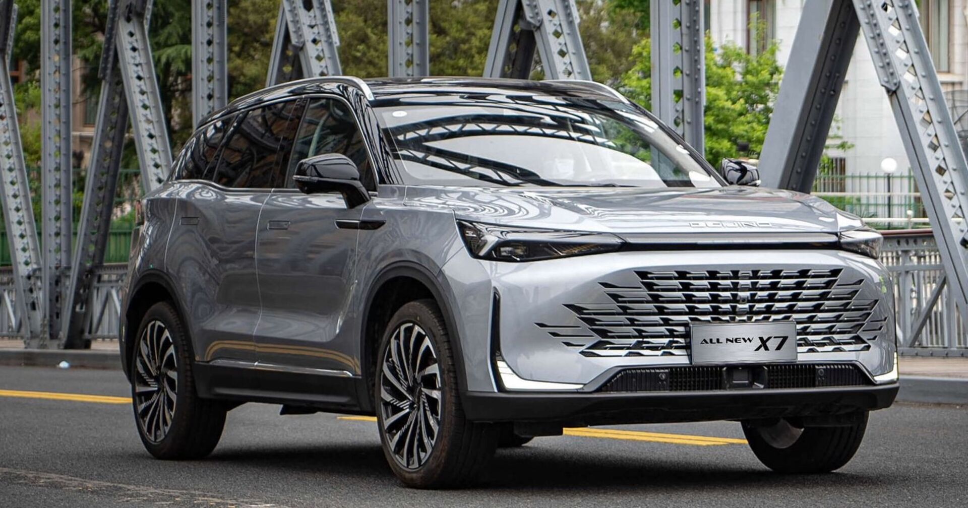 Ein graues SUV, Modell BAIC Beijing X7, fährt über eine Brücke