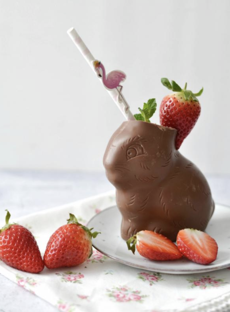 Schokoosterhase gefüllt mit Buttermilch und Strohhalm, dekoriert mit Erdbeeren.