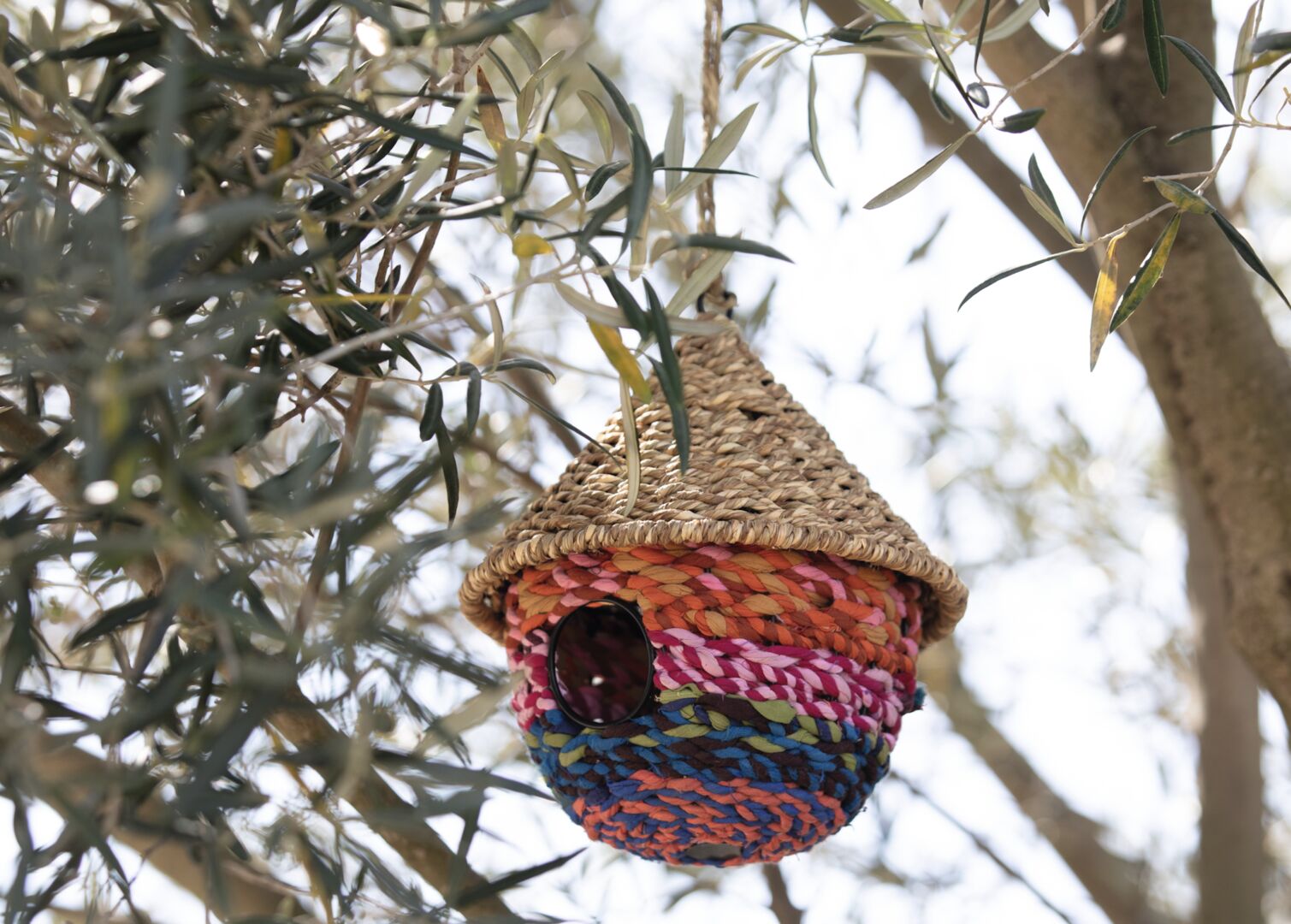 Buntes Stoffvogelhaus im Baum hängend