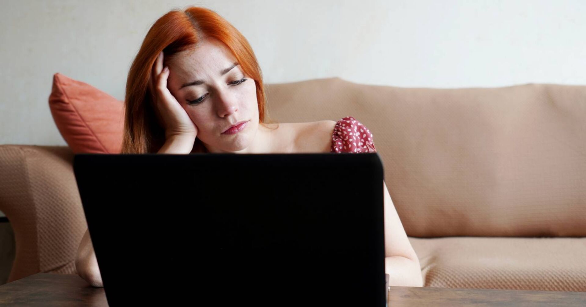 Frustrierte Frau vor ihrem aufgeklappten Laptop