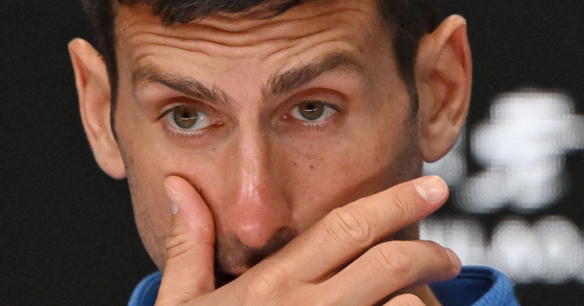 Djokovic im Porträt, er runzelt die Stirn und hat die Hand vor dem Mund.
