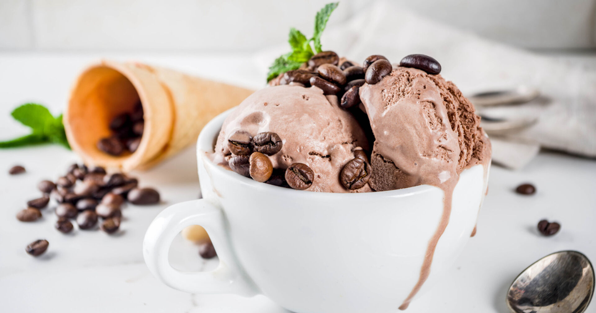 Kaffeeeis und Kaffeebohnen in einer weißen Tasse