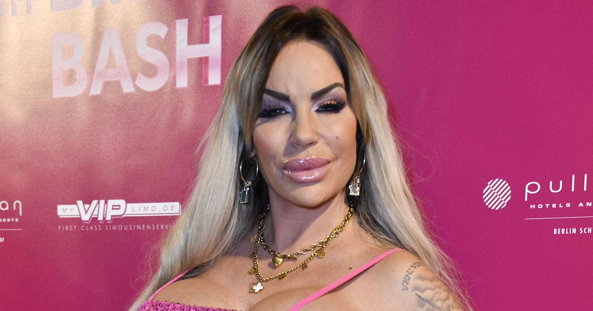 Gina Lisa Lohnfink vor einer pinken Fotowand.