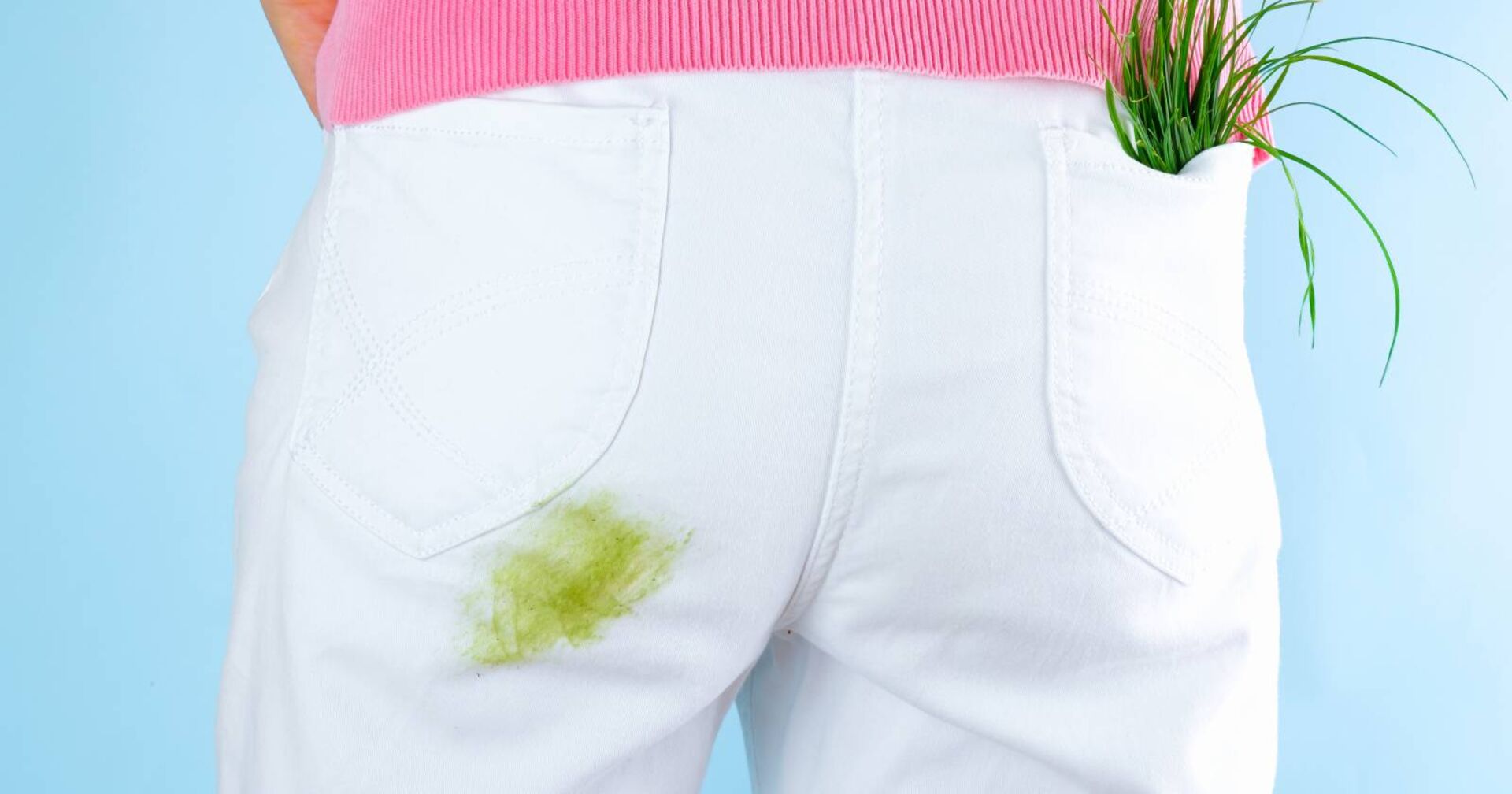 Detailansicht einer weißen Hose mit grünem Grasfleck über dem Gesäß.