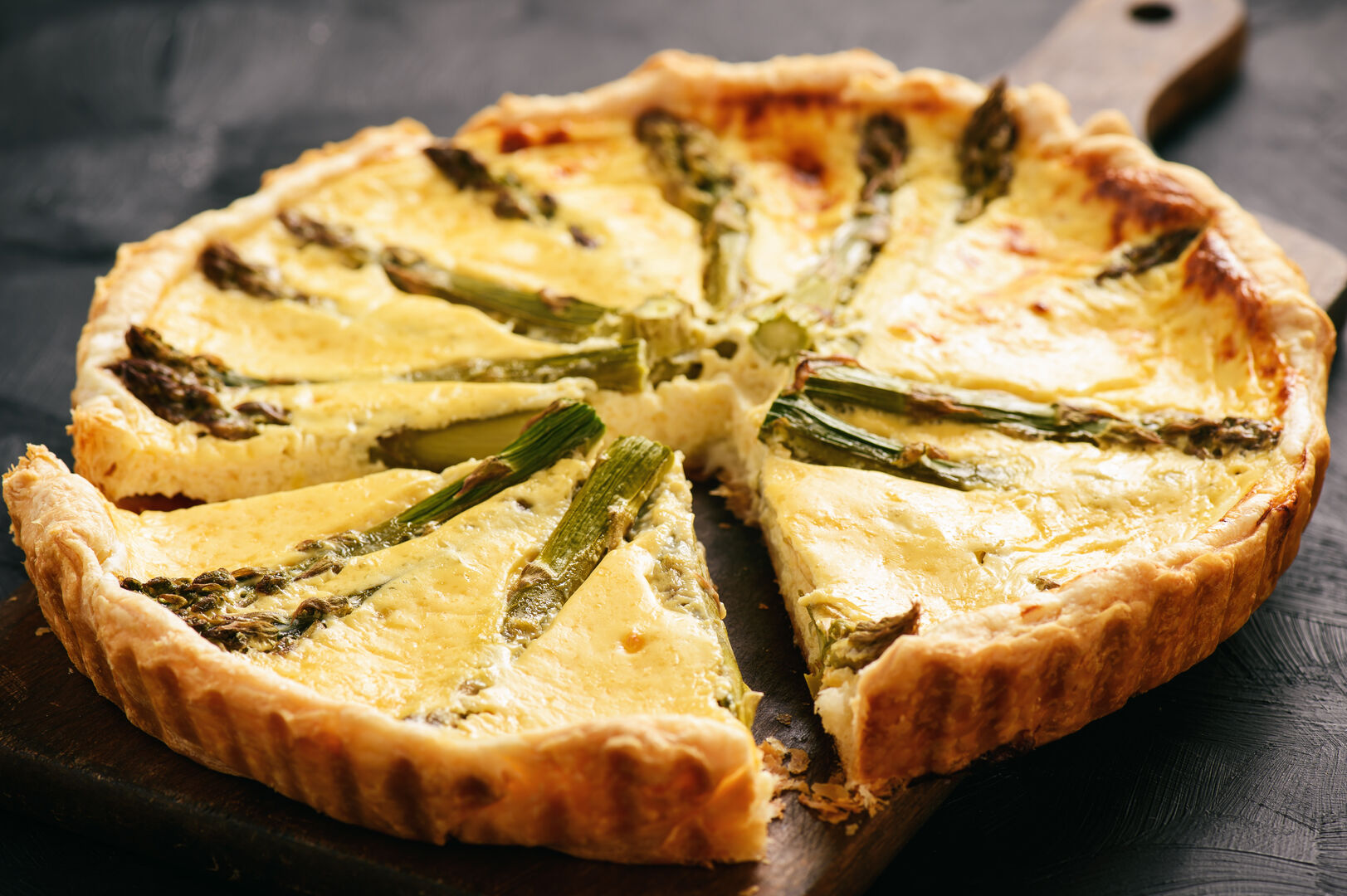 Eine Spargel Quiche auf einem Holzbrett