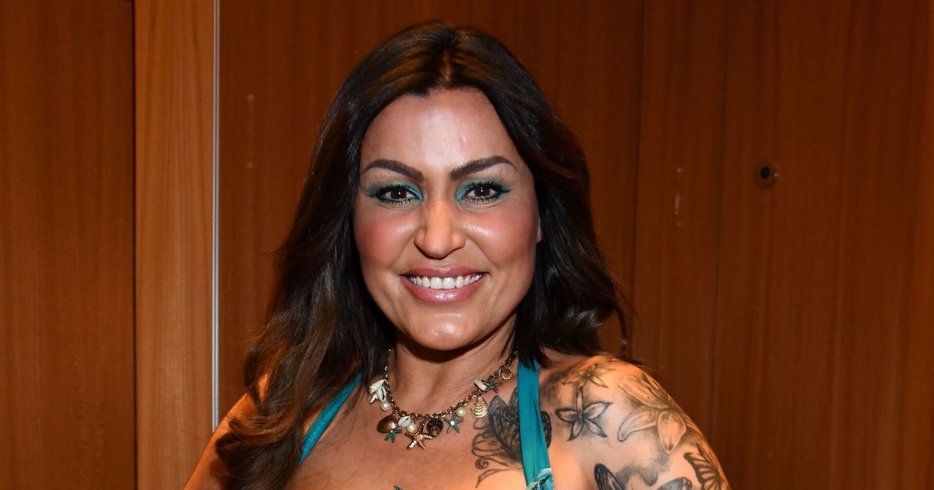 Jasmin Herren mit offenen braunen Haaren und Tattoos.