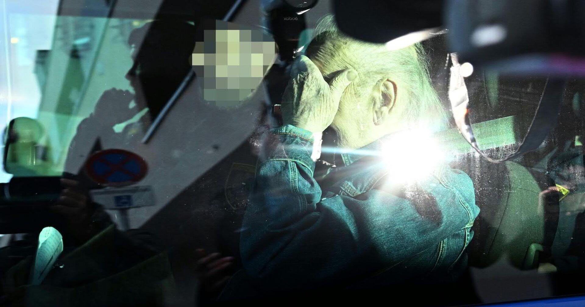 Josef Fritzl verdeckt im Auto mit der Hand sein Gesicht.