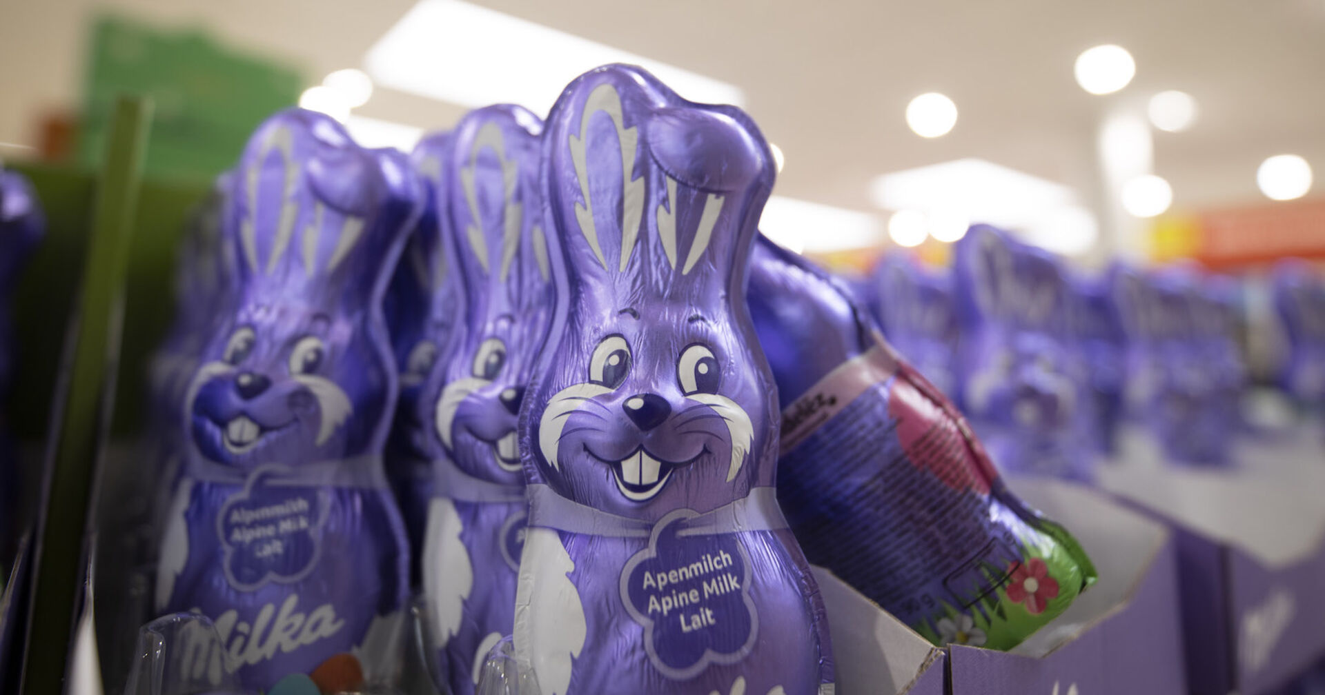 Milka-Schokohasen in einem Supermarktregal.
