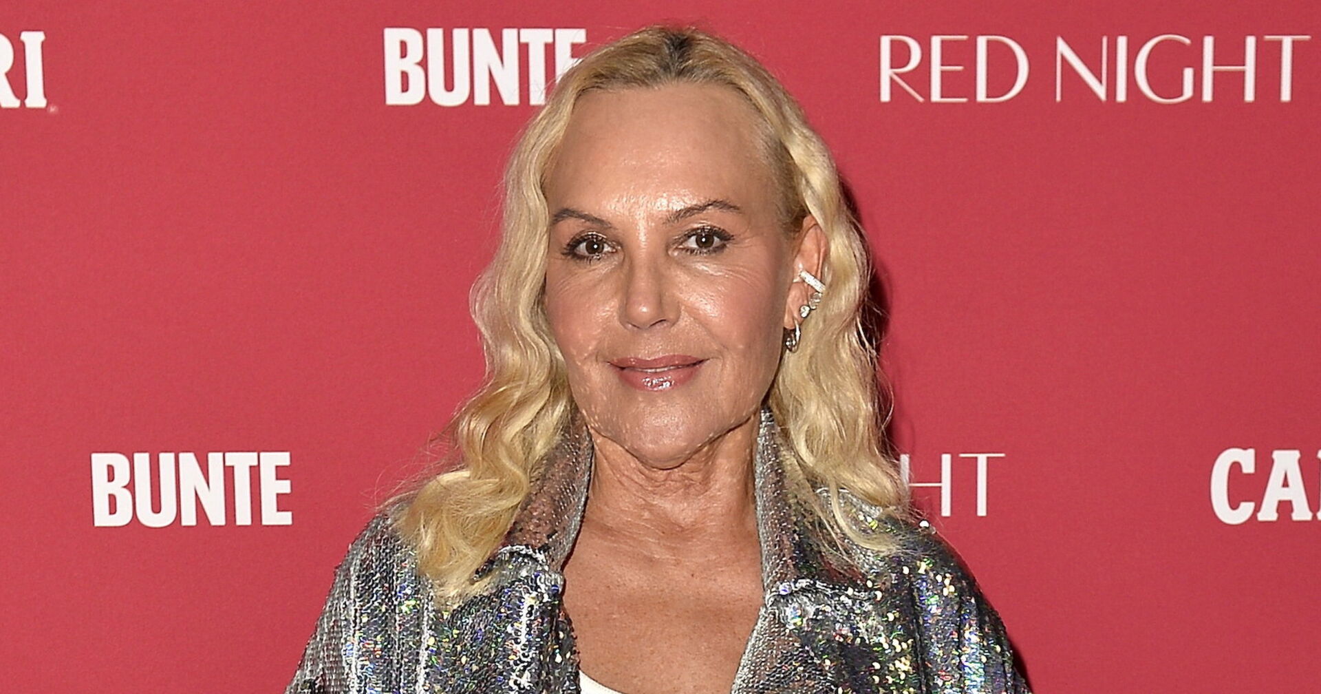 Natascha Ochsenknecht mit blonden gewellten Haaren und einem glitzernen Hemd.