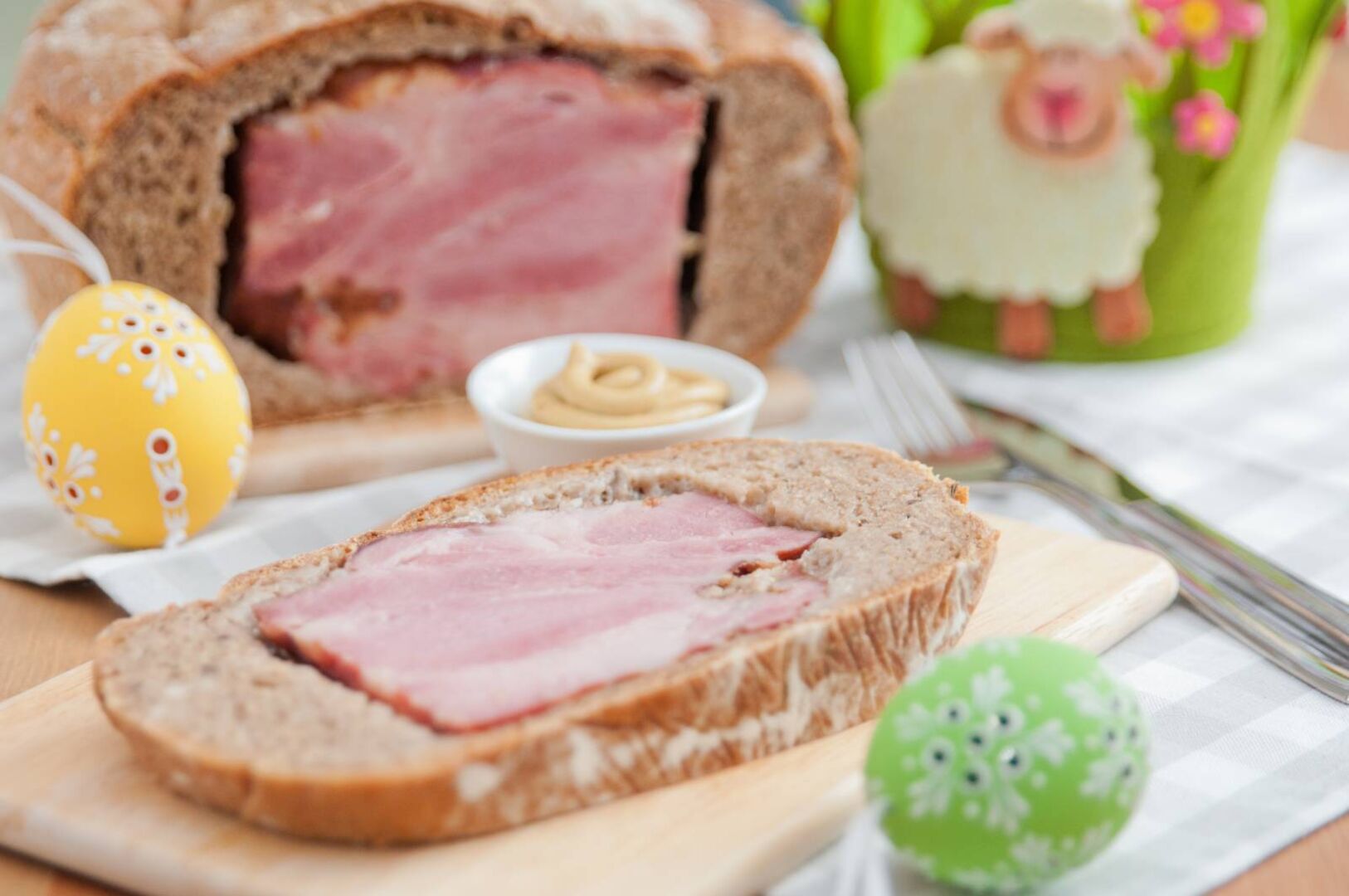 Aufgeschnittener, gekochter Schinken der in einem Laib frischen Brot eingefasst ist