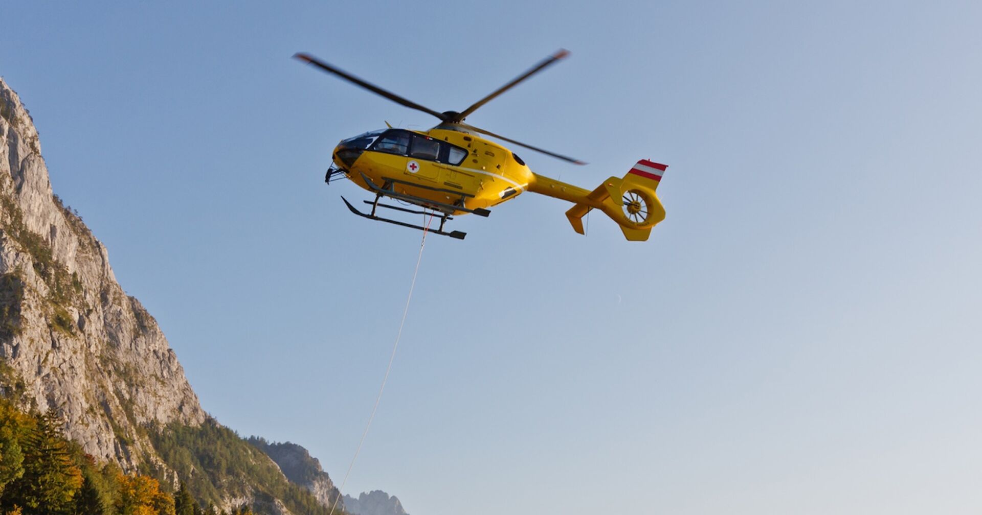 Gelber ÖAMTC-Hubschrauber im Einsatz.