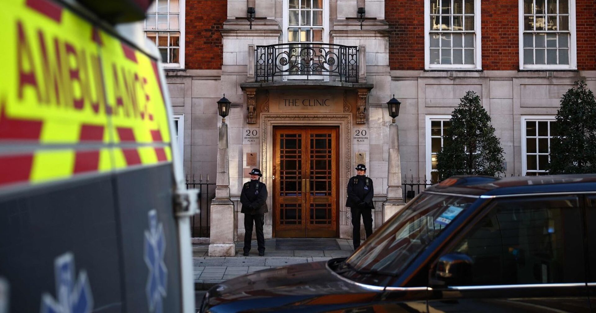 Die London Clinic in der Prinzessin Kate operiert wurde, wird von Polizisten bewacht. Davor parkt ein Rettungswagen.