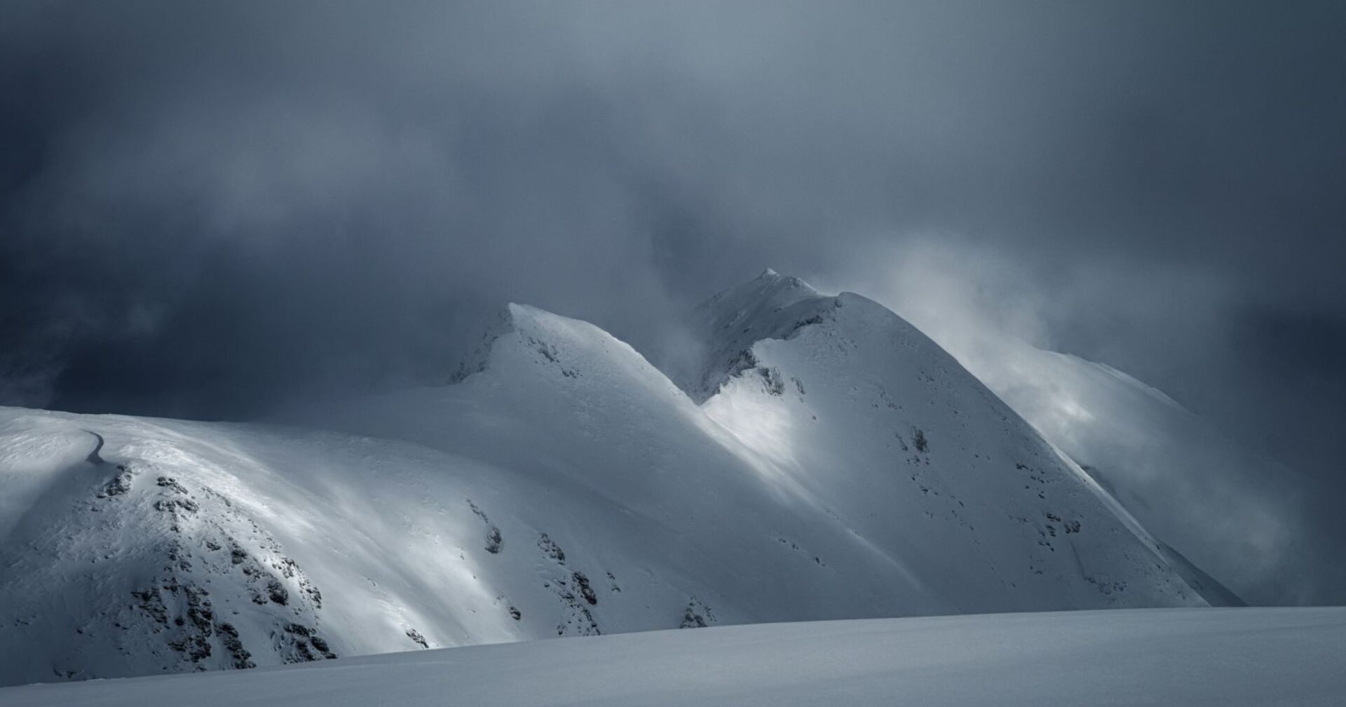 Ein düsteres Bild von einem schneebedeckten Berg.