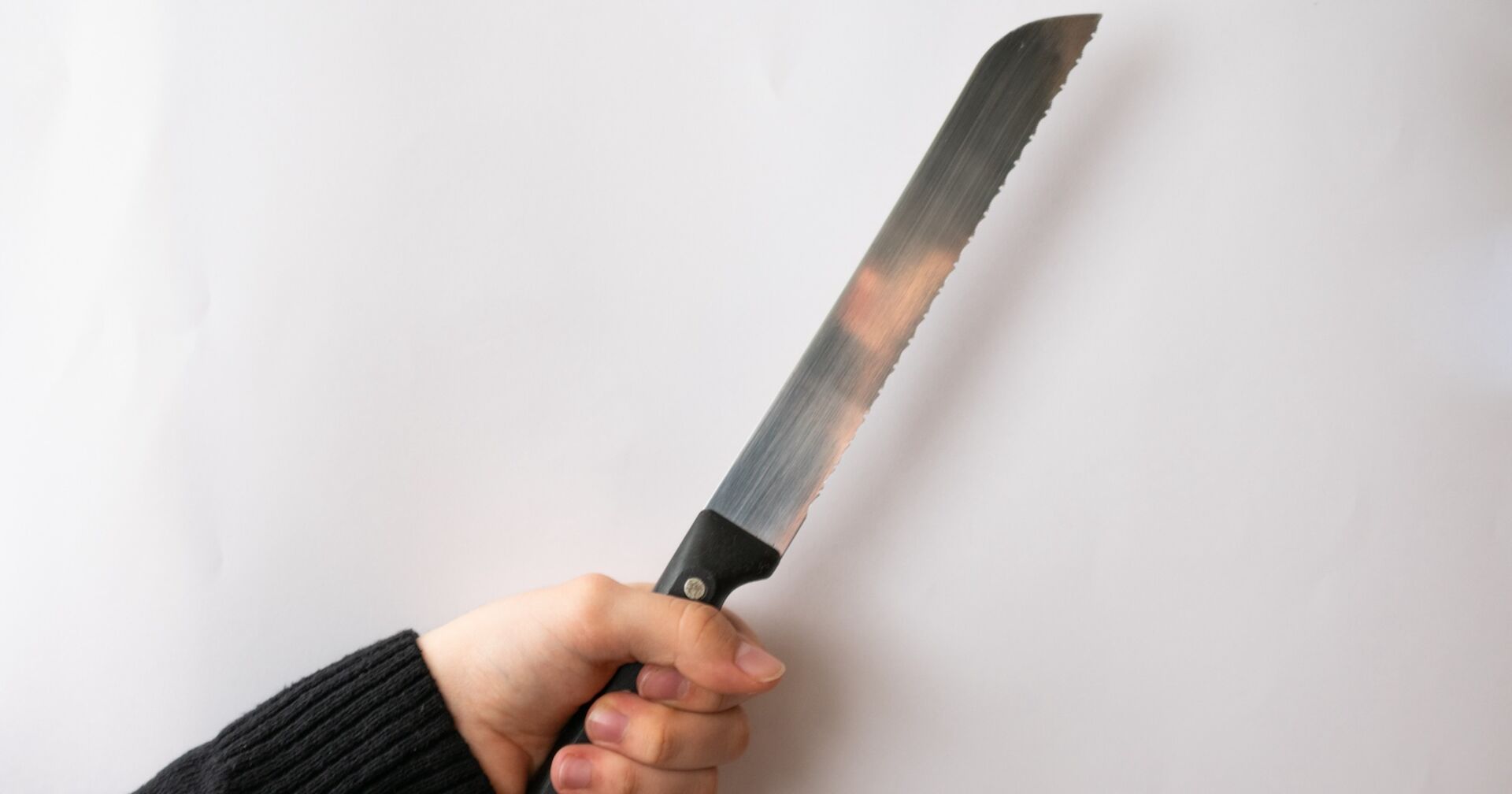 Eine Person hält ein Brotmesser in der Hand.