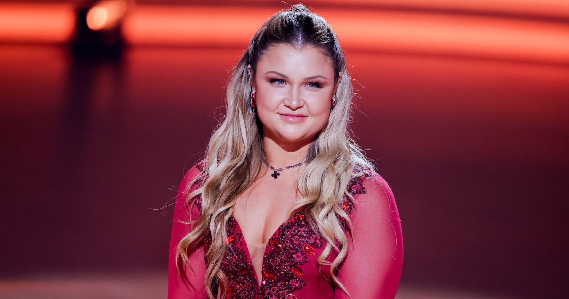 Sophia Thiel mit offenen gewellten Haaren und einem roten Kleid.