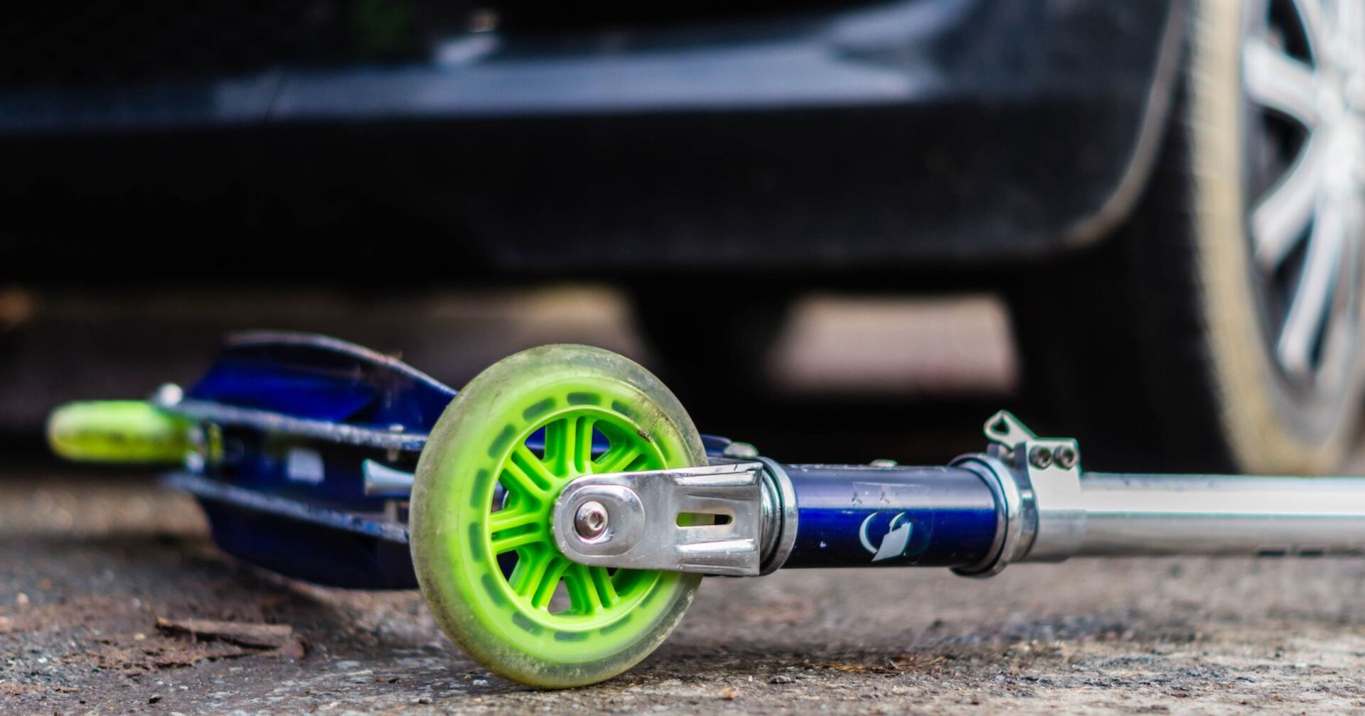 Kinder-Scooter liegt unter einem Auto.