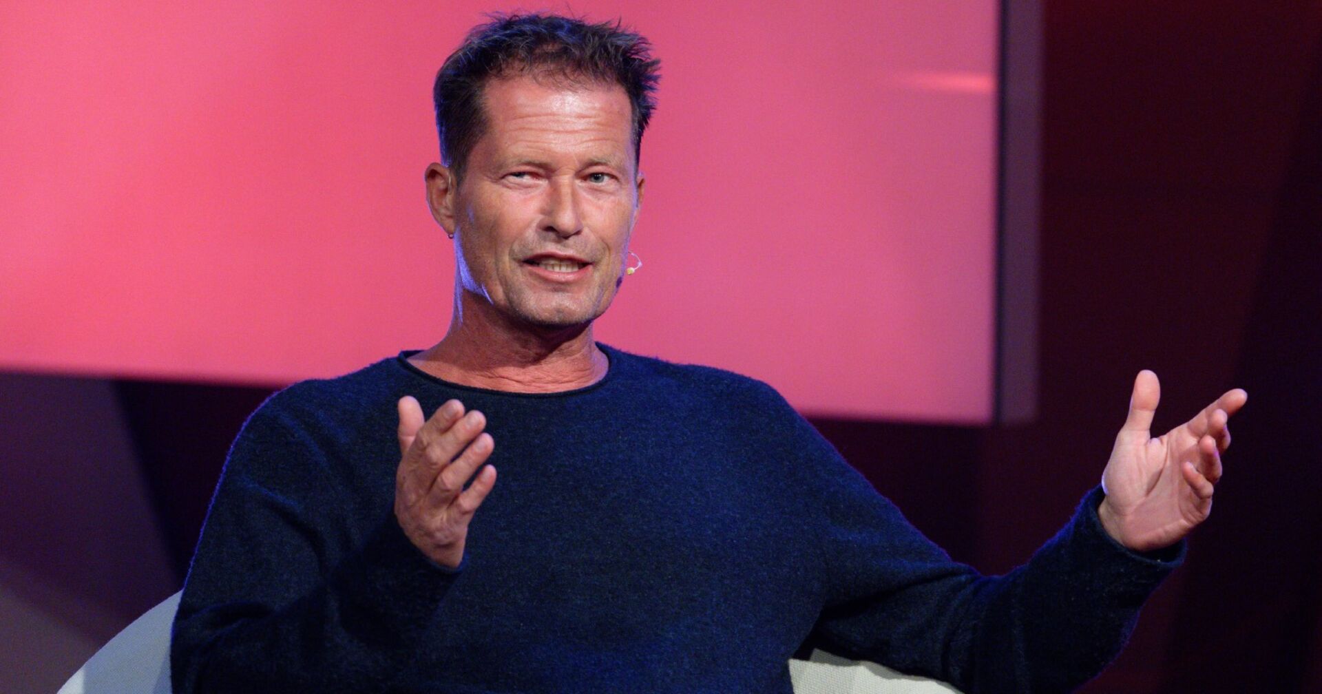 Till Schweiger sitzt bei einem Interview und gestikuliert mit den Händen