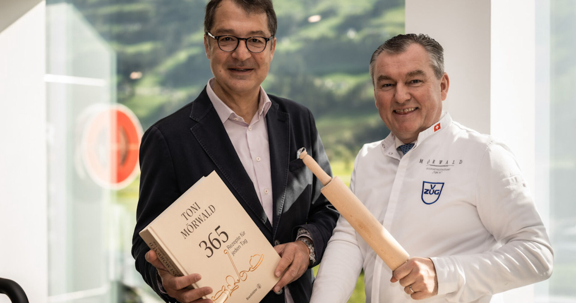 Mann mit Kochbuch und Koch mit Nudelholz