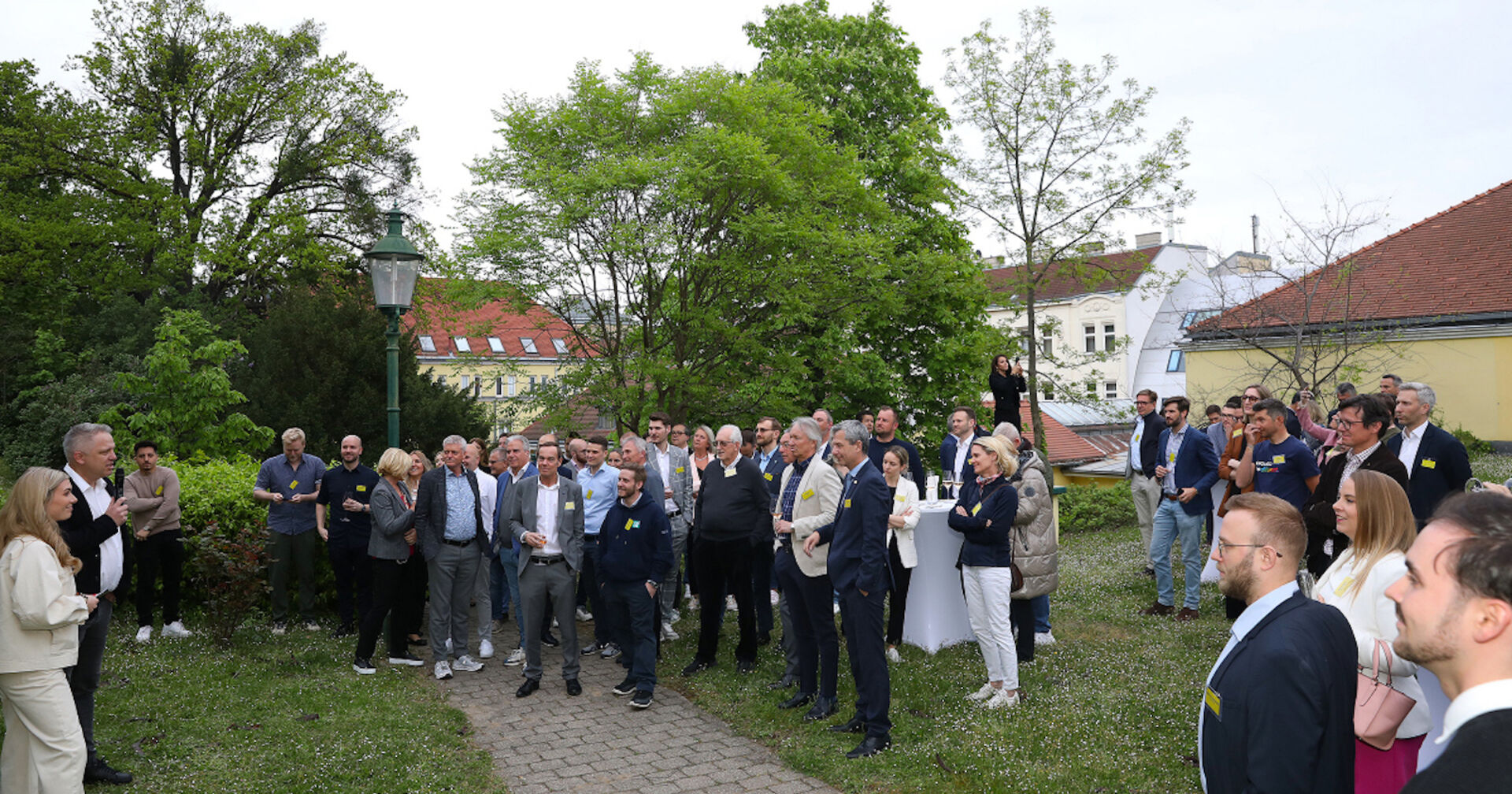 Größere Menschengruppe im Garten, ein Redner