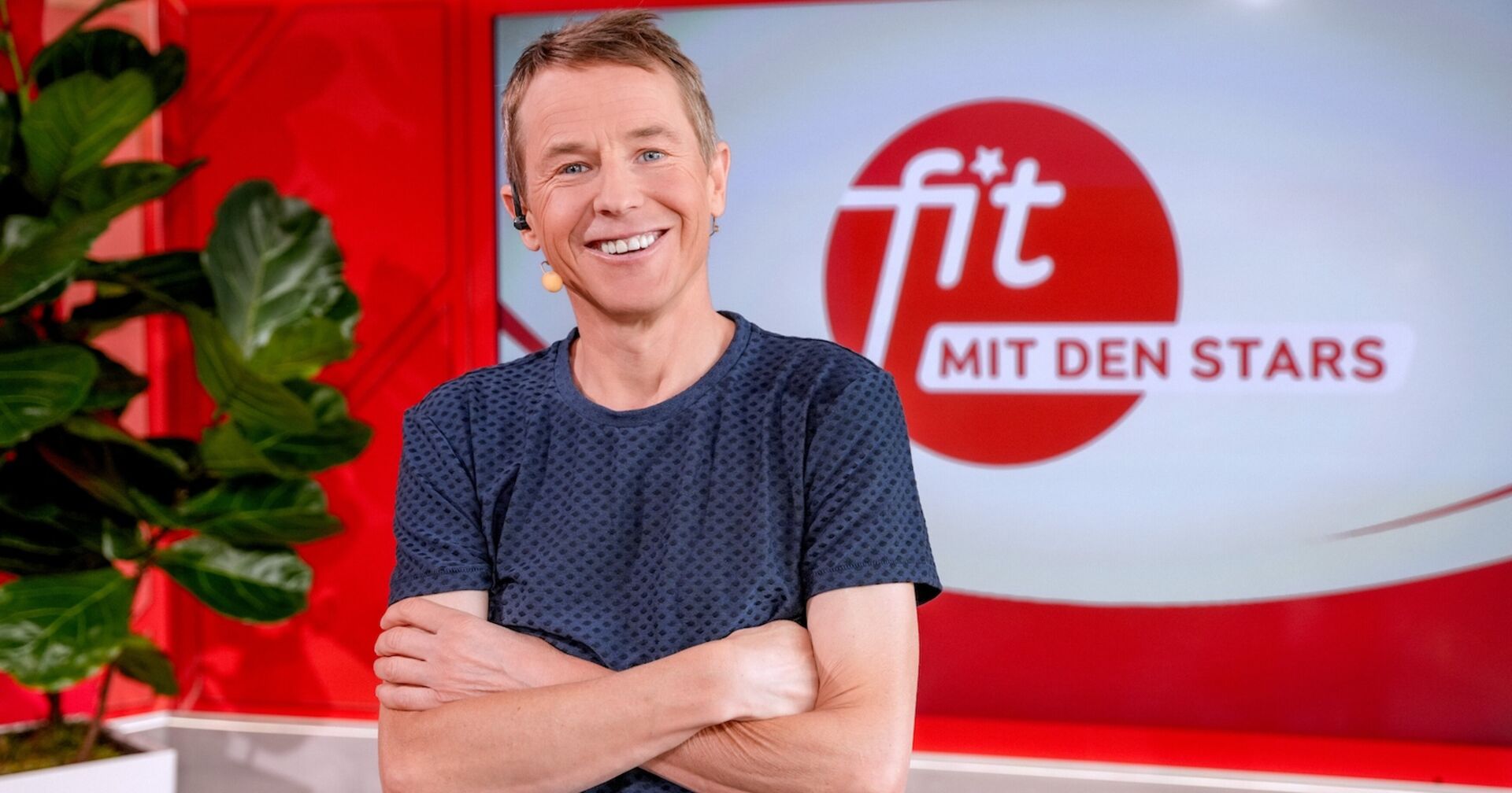 Andi Goldberger am Set von Fit mit den Stars in einem blaen T-Shirt.