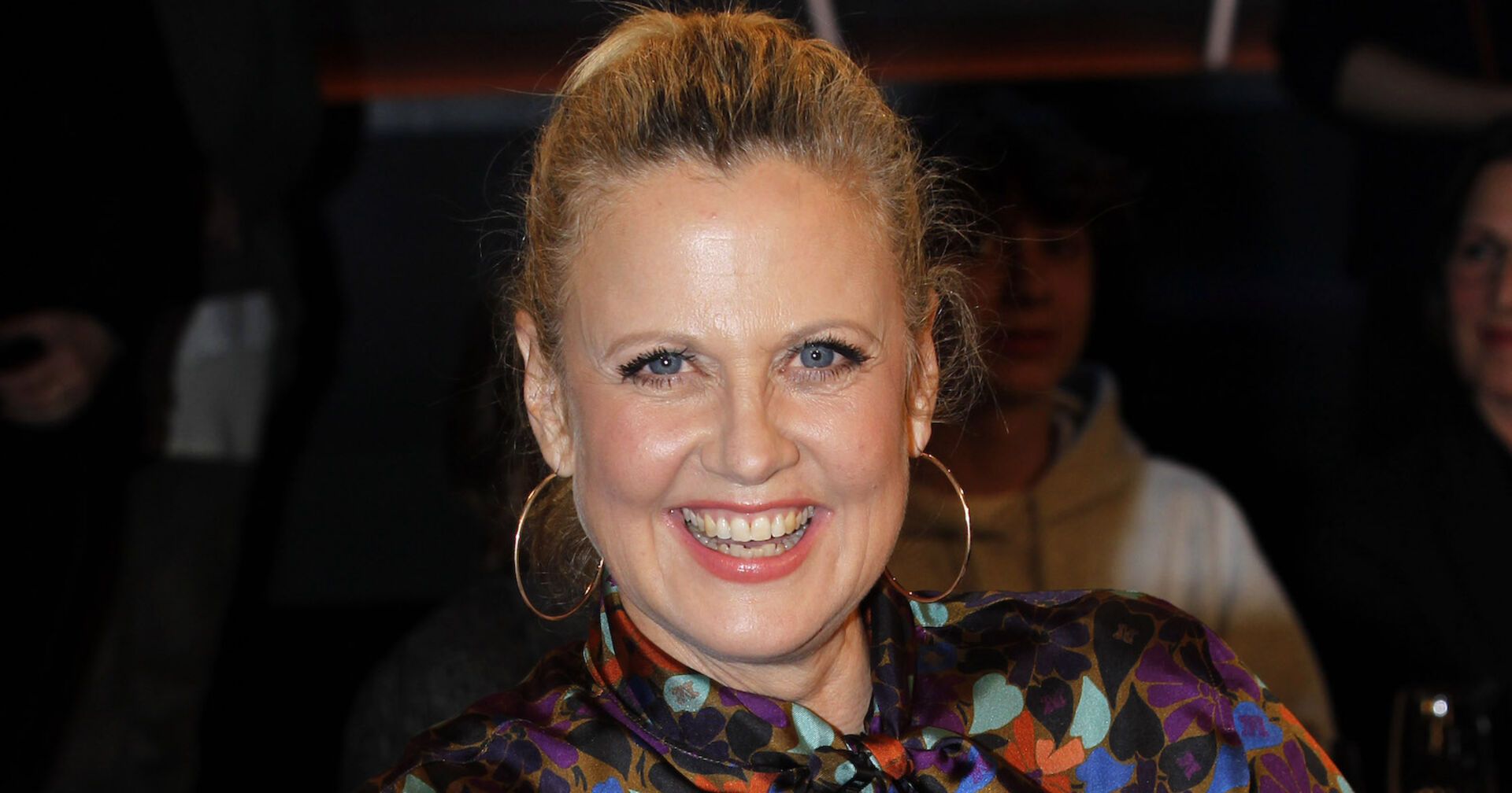 Barbara Schöneberger mit einem geschlossenen Zopf und Ohrringen.