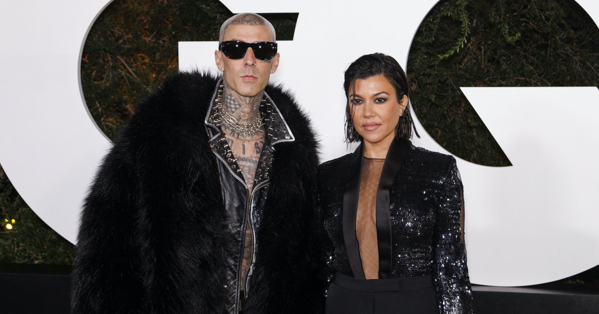 Travis Barker und Kourntey Kardashian in schwarzen Outfits.
