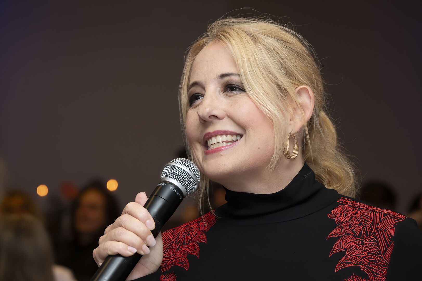 Blonde Frau singt ins Mikrofon